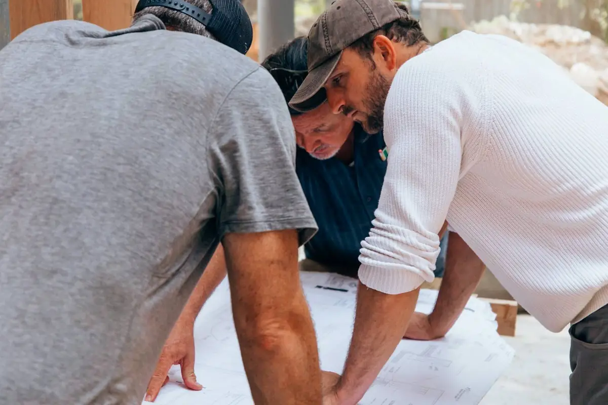 Project manager and site team reviewing construction drawings